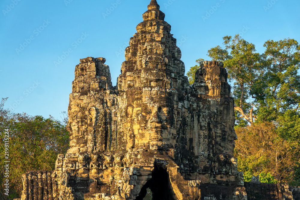 Obraz premium Giant stone Buddha face at Angkor Thom ancient city South gate, Angkor at sunset, Siem Reap, Cambodia