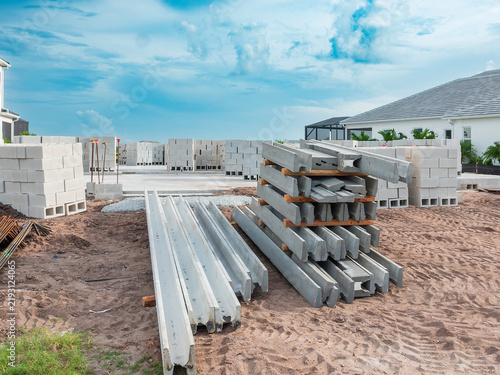 Foto Lintels of various lengths delivered to a house construction site, with stacks of concrete blocks arranged on slab foundation, in an upscale suburban residential development in Florida