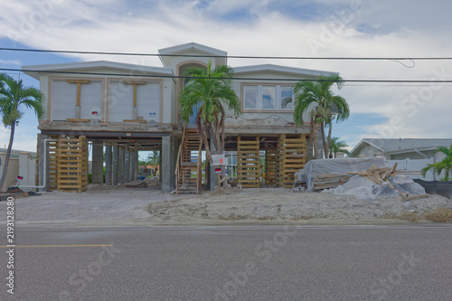 Canvastavla A coastal two-story house raised on concrete pilings and temporary wooden suppor