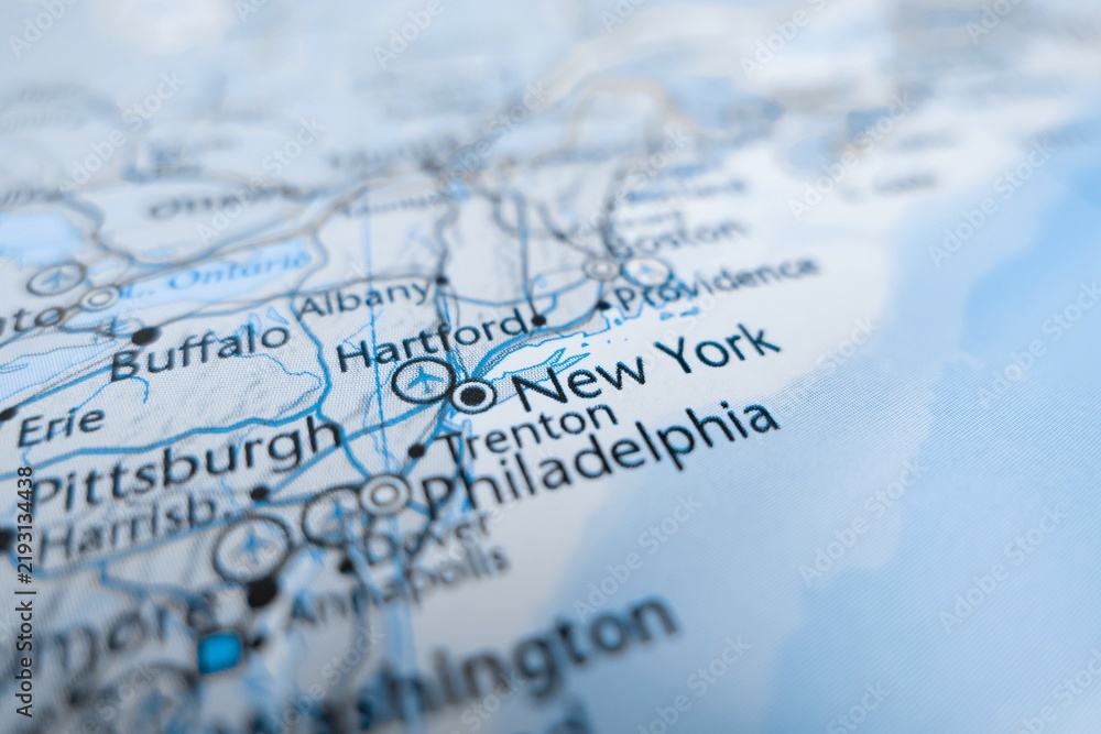 Fototapeta premium Map of New York styled in grey color. Selective focus on label, close-up view