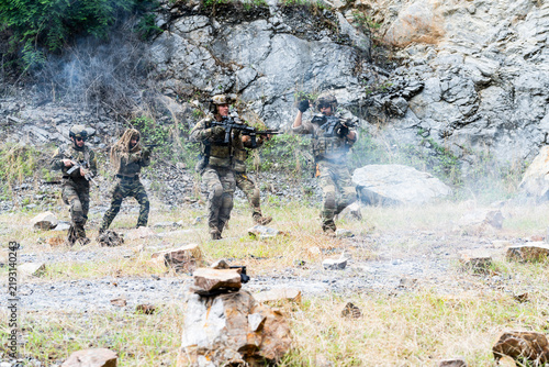 Canvas Print Military training exercise in a rocky terrain with soldiers performing various a