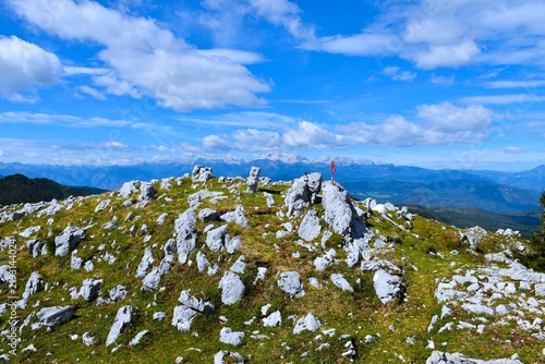 Rocky terrain at the top of Kosmati vrh with a view of Triglav mountain in Julian alps in the distance in Gorenjska, Slovenia