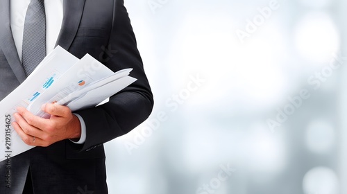 Business Professional Holding Financial Reports in Modern Office Environment