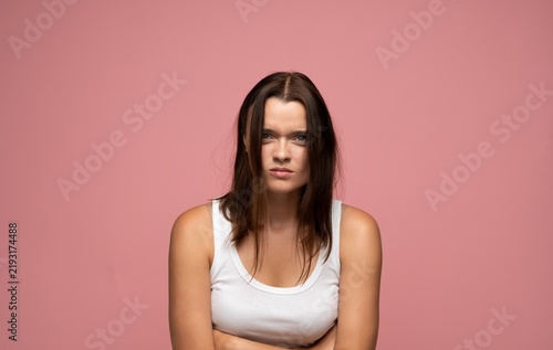 Bild auf Leinwand Young woman feeling angry and frustrated, frowning with arms crossed, having a b