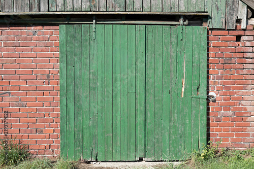 Rustic green barn sliding door on brick wall