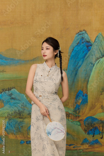 Cuadro en lienzo Elegant woman in traditional Chinese dress with round fan against classical moun