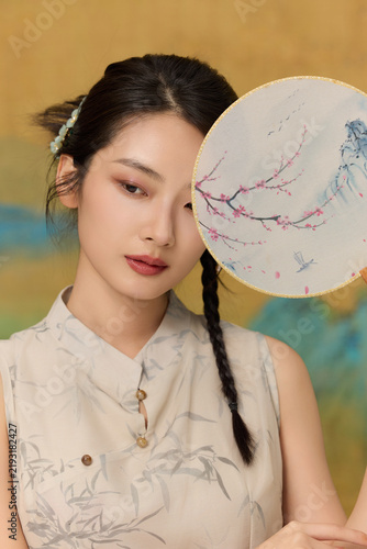 фотографія Elegant young woman with painted silk fan in traditional Chinese style