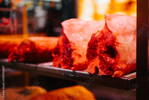 Obraz na płótnie Raw cuts of meat are neatly arranged on display shelves in a butcher shop