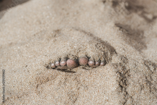 Dedos de los pies enterrados en la arena de la playa