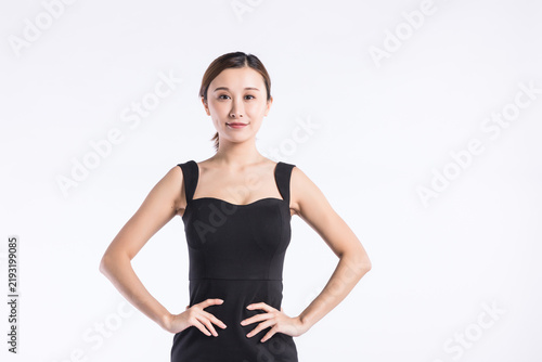 Fotografía Confident young Asian woman in black dress posing with hands on hips