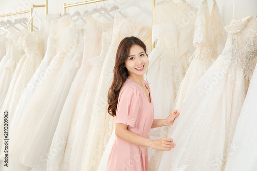 Happy Bride Choosing Wedding Dress in Bridal Shop