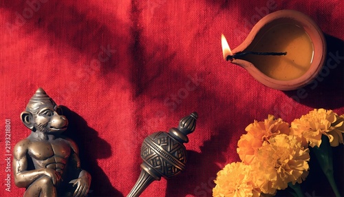Traditional indian religious scene with hanuman statue, marigold flowers, and clay oil lamp for festive background and spiritual design