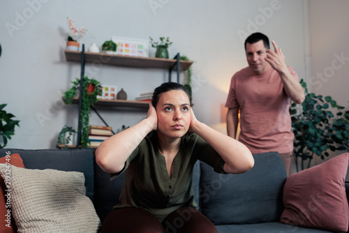 фотографія Woman covering ears enduring toxic relationship argument