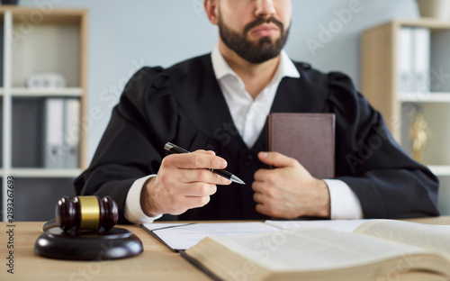 Картината върху платно Close-up of man judge signing verdict in courtroom during criminal justice session, focusing on law and judgment in a professional setting with a sense of legal enforcement and authoritative decision