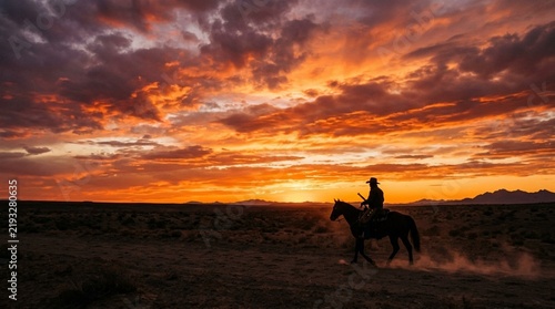 Cowboy riding horse silhouette at dramatic sunset, dusty western landscape.