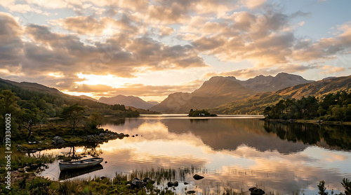 Sunset reflection on calm lake with mountain views