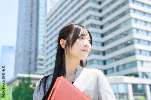 Naklejka ビル街でバインダーを持つ日本人女性