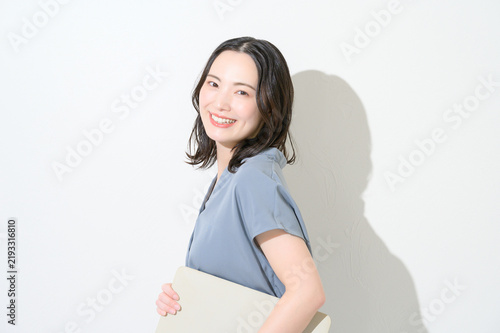 Naklejka 白背景でノートパソコンを持って微笑む日本人女性