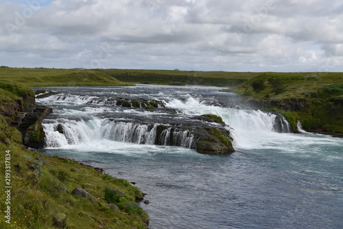 Scenic Cascading Waterfall in Green Icelandic Landscape