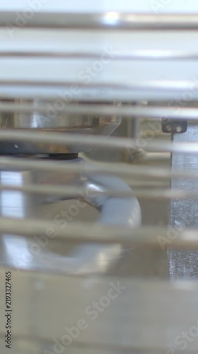stationary metal appliance interior components shown behind horizontal grill bars with circular gasket seal and stacked trays in tight close view detail, with