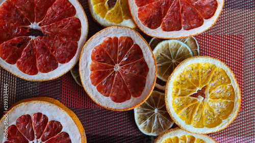 Slices of citrus fruits arranged on a table showing various colors and types of fruit