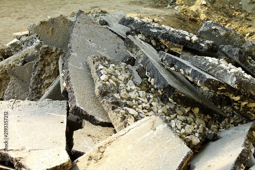 Принти на полотні Three broken asphalt pieces dominate the foreground, while removed pavement slabs overlap behind them in layered forms during road renovation