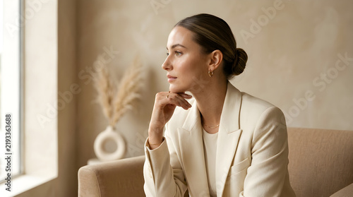 Professional woman thinking thoughtfully by the window in a light room