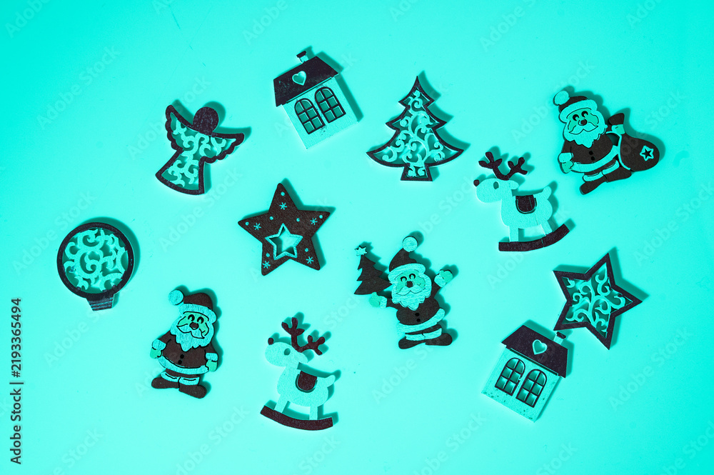Fototapeta premium Various wooden Christmas ornaments placed on a teal background