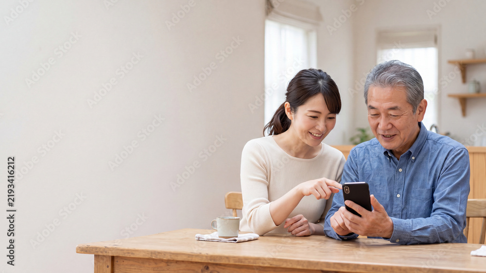 Obraz premium 若い女性からスマートフォンの使い方を教わるシニア男性