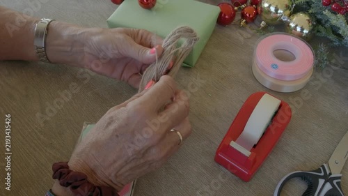 Woman preparing twine for christmas gift wrapping
