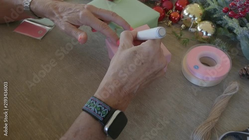 Woman writing name tag for christmas present