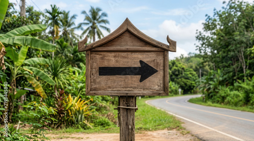 Wooden Directional Sign Points Right Along Scenic Tropical Road