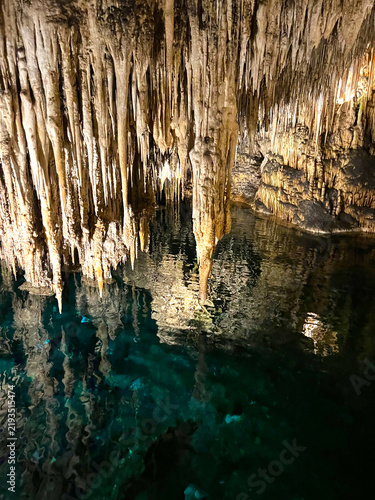 Cuadro en lienzo Magnificent limestone stalactites hanging above crystal clear turquoise undergro
