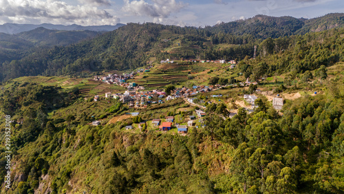 Aerial view of shola forest vegetation in Kookal, Palani Hills, Western Ghats, featuring Rudraksha, Jamun, cinnamon, grasslands, pine trees, and scattered village houses across the lush mountain lands