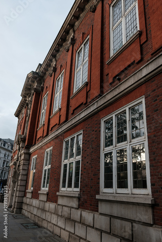 Canvas Print Red brick building facade with white frame windows