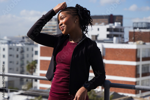 Cuadro en lienzo African American woman leaning on rooftop railing wearing maroon dress  and  bla