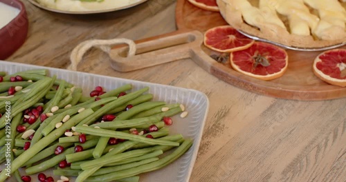 Camera is starting to pan right and up, revealing green beans and pie to show spread