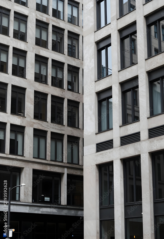 Fototapeta premium Urban development and corporate architecture, modern office building facade with stone cladding and glass windows in a dense city business district