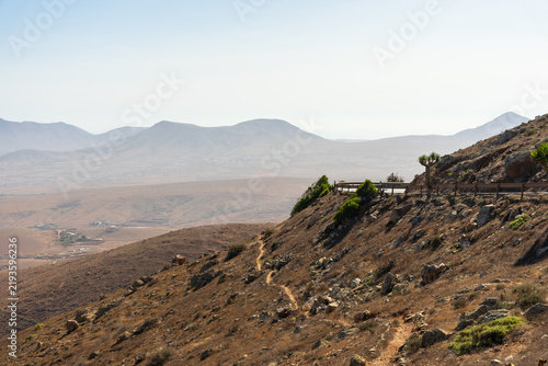 Obraz na płótnie Mountain viewpoint with scenic road overlooking arid valley at Mirador de Guise y Ayose, Fuerteventura, Canary Islands, Spain