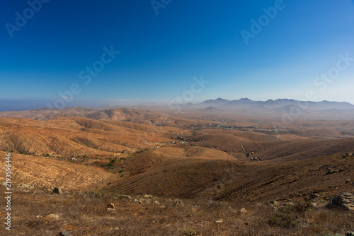 Obraz na płótnie Aerial view of arid valley and volcanic mountains under clear sky from Mirador de Guise y Ayose, Fuerteventura, Canary Islands, Spain