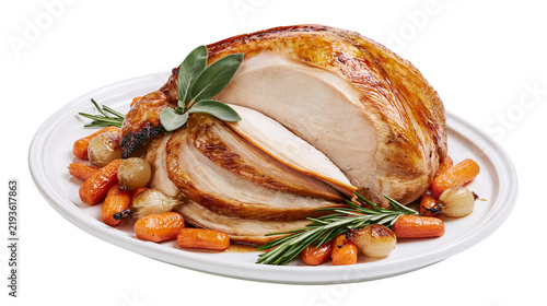 Isolated delicious roasted turkey breast, perfectly carved, with fresh herbs and vegetables.