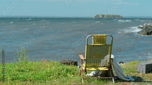 deck chair mockup on a grass beach with blue sea background, rear view