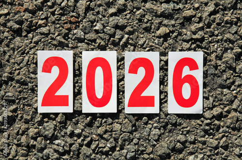 Huge numbers of 2026 year. Paper square numbers on the stone road background. Autumn of year of 2026, year of the red fire horse. Numbers of current, passing year. Symbols of 2026