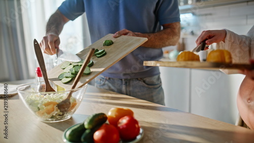 Expecting parents preparing vegetable salad kitchen. Closeup hands chopping.