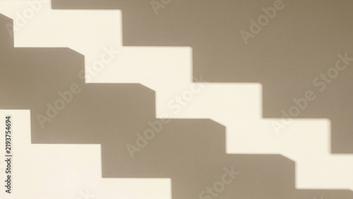 Geometric silhouette shadow of a staircase on a plain wall
