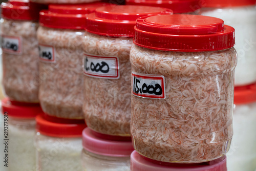 Traditional fermented salted tiny shrimps in clear plastic jars are displayed for sale at a traditional five day market in South Korea.