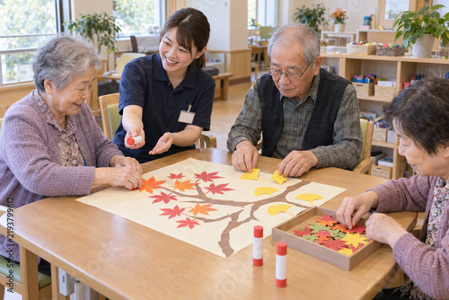 Japanese seniors making autumn paper crafts at an adult day care center