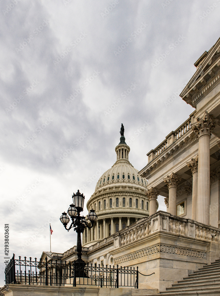 Obraz premium Capitol patriotic skyline in Washington DC clouds. National architecture facade in Washington DC blue sky. Washington government Congress Senate law Washington. Historic democracy symbol.