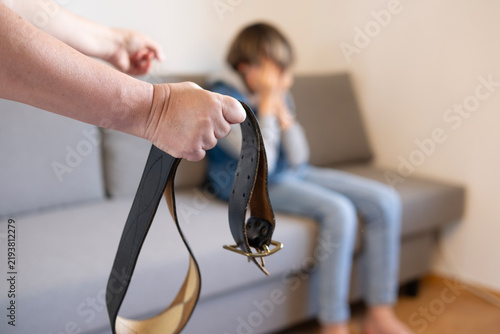 Картината върху платно wide leather belt in female parent's hand threatens misbehaving teenage boy sitt