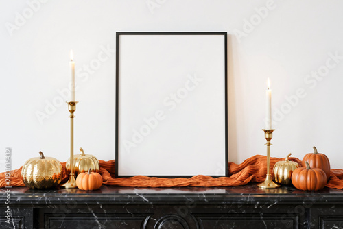 Picture frame mockup arranged on a dark marble fireplace mantel with pumpkins, taper candles, and soft orange runner